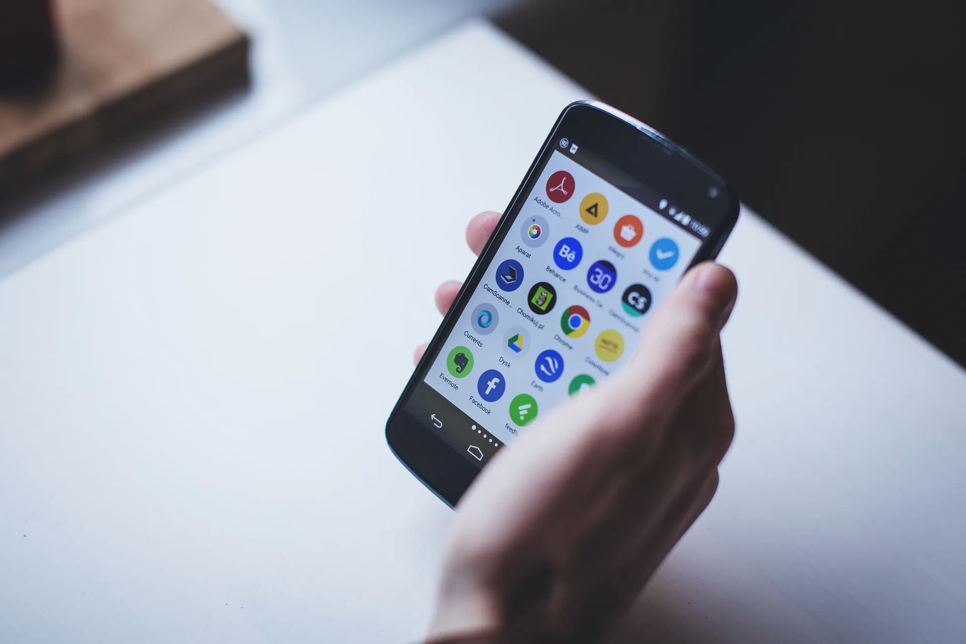 A person holding a smartphone displaying mobile applications
